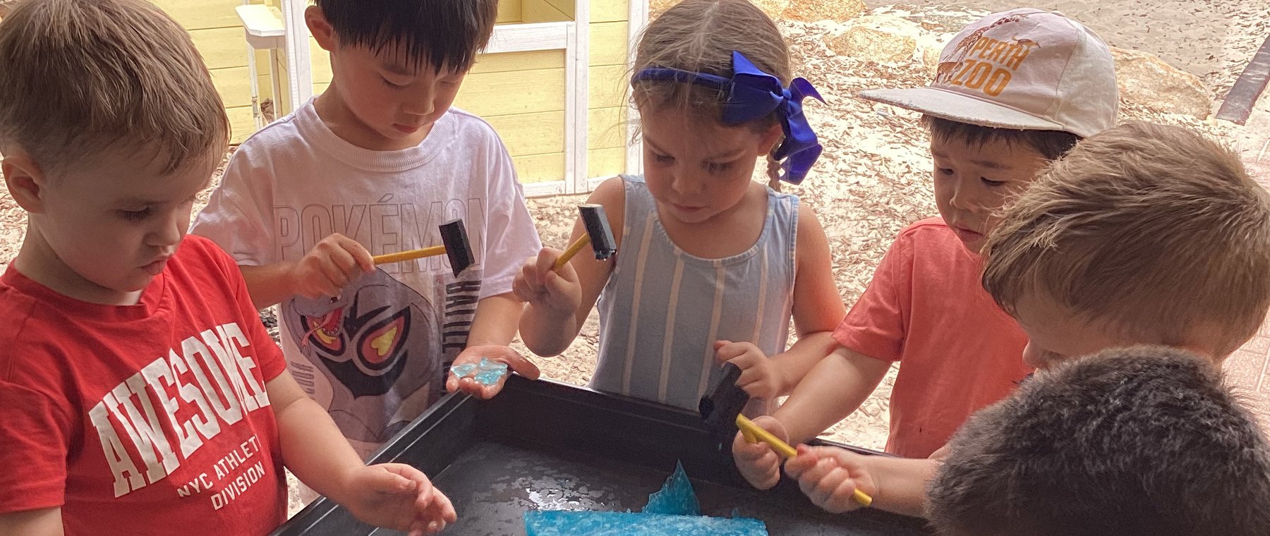 Children exploring an ice-block sensory activity together &mdash; the kind of moment shared via the family portal